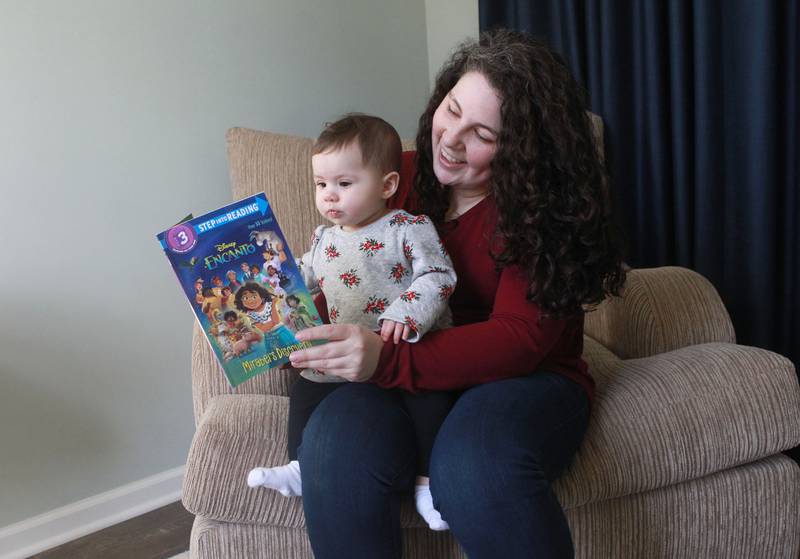 Children's book author Vicky Weber reads the book, "Encanto Mirabel's Discovery," to her daughter, Eliana, 7 months old, in 2021 at their home in Gurnee. Weber has launched a coaching and consulting business with two other former teachers.