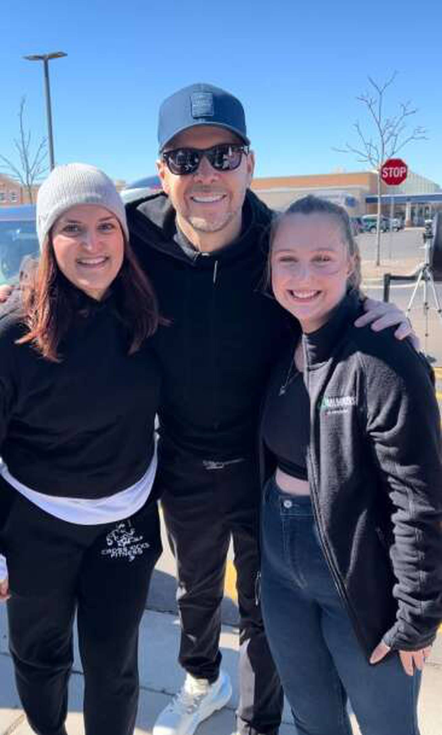 New Kids on the Block fan Arezou Kashani Soto (left) and Grace Yehl pose with Donnie Wahlberg following their flash mob performance on March 10, 2024 in St. Charles.