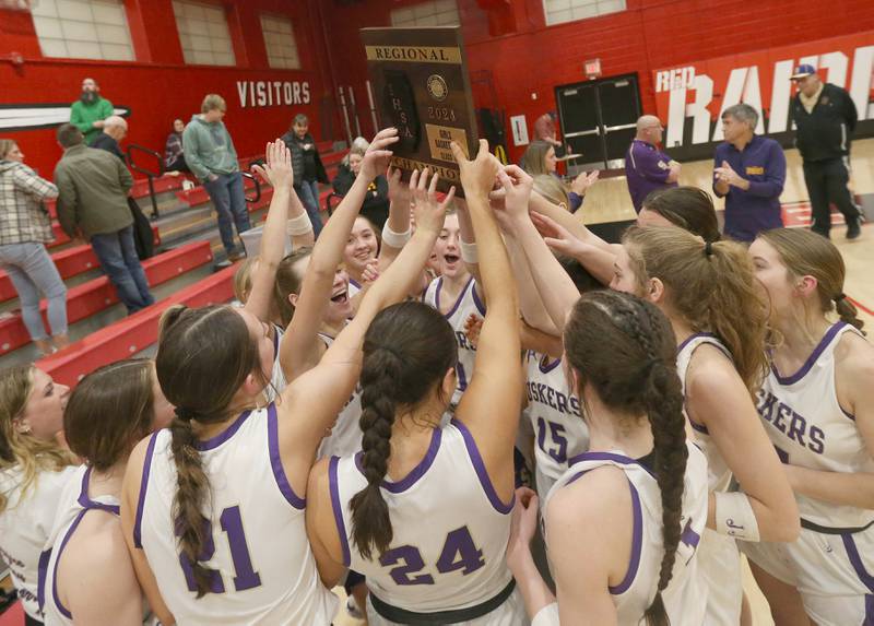 Members of the Serena girls basketball team hoist the Class 1A Regional plaque after defeating Ashton-Franklin Center on Thursday, Feb. 15, 2024 at Earlville High School.