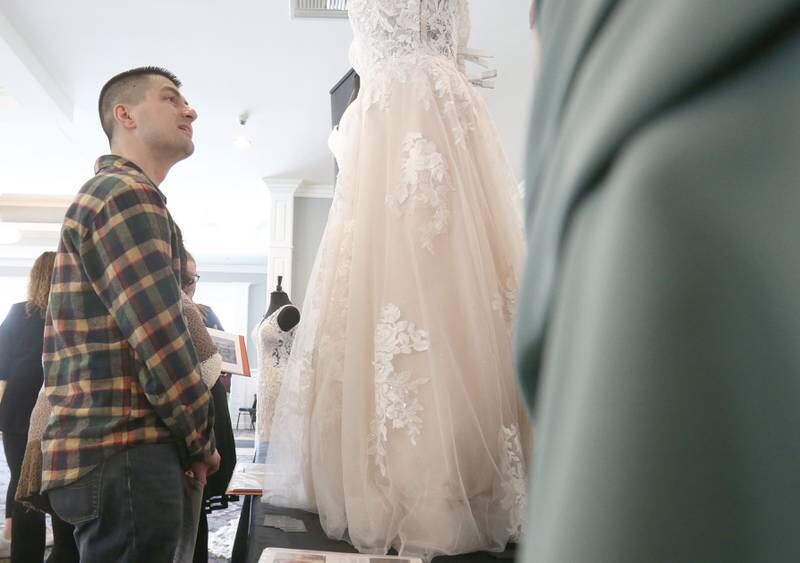 Future groom Dylan Guerrero, glances at wedding dresses while walking through the Shaw Local Radio Bridal and Event Expo on Sunday, Feb. 23, 2025 at Senica's Oak Ridge in La Salle.