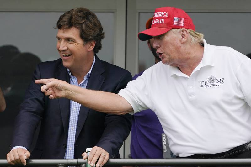 Tucker Carlson, left, and former President Donald Trump, talk while watching golfers on the 16th tee during the final round of the LIV Golf Invitational at Trump National in Bedminster, N.J., July 31, 2022. A defamation lawsuit against Fox News is revealing blunt behind-the-scenes opinions by its top figures about Donald Trump, including a Tucker Carlson text message where he said “I hate him passionately.” Carlson's private conversation was revealed in court papers at virtually the same time as the former president was hailing the Fox News host on social media for a “great job” for using U.S. Capitol security video to produce a false narrative of the Jan. 6, 2021, insurrection.  (AP Photo/Seth Wenig, File)