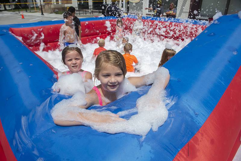 Sophia Richards (front), 7, and sister Alayna, 5, lounge in the sudsy pool party hosted for kids at Morrison’s Shuckfest. The first year event featured, music, vendors, food and of course the star of the show, roasted sweet corn.