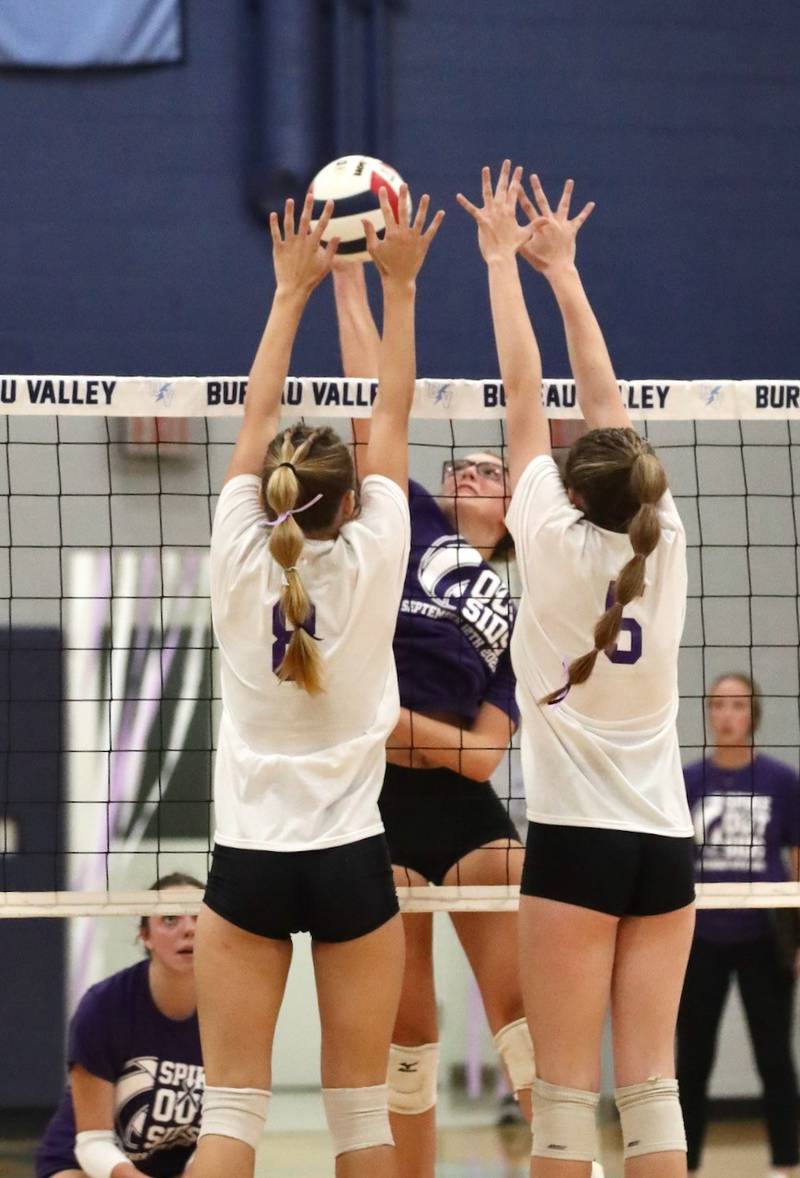 Bureau Valley senior Emma Stabler hits against Princeton's Keighley Davis (8) and Caroline Keutzer (6) Tuesday night at the Storm Cellar.