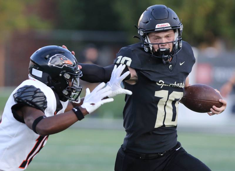 Sycamore's Burke Gautcher tries to get by DeKalb’s Rahsheed Greer during the First National Challenge game Friday, Aug. 25, 2023, in Huskie Stadium at Northern Illinois University in DeKalb.