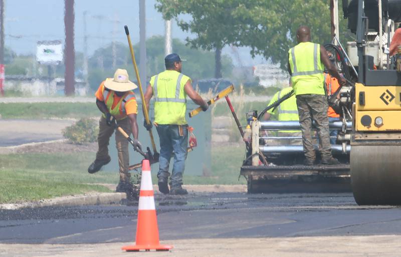 Workers with Advanced Asphalt pave the north entrance to the Peru Mall on Monday, July 17, 2023 in Peru. The project is on private property and is not city funded.