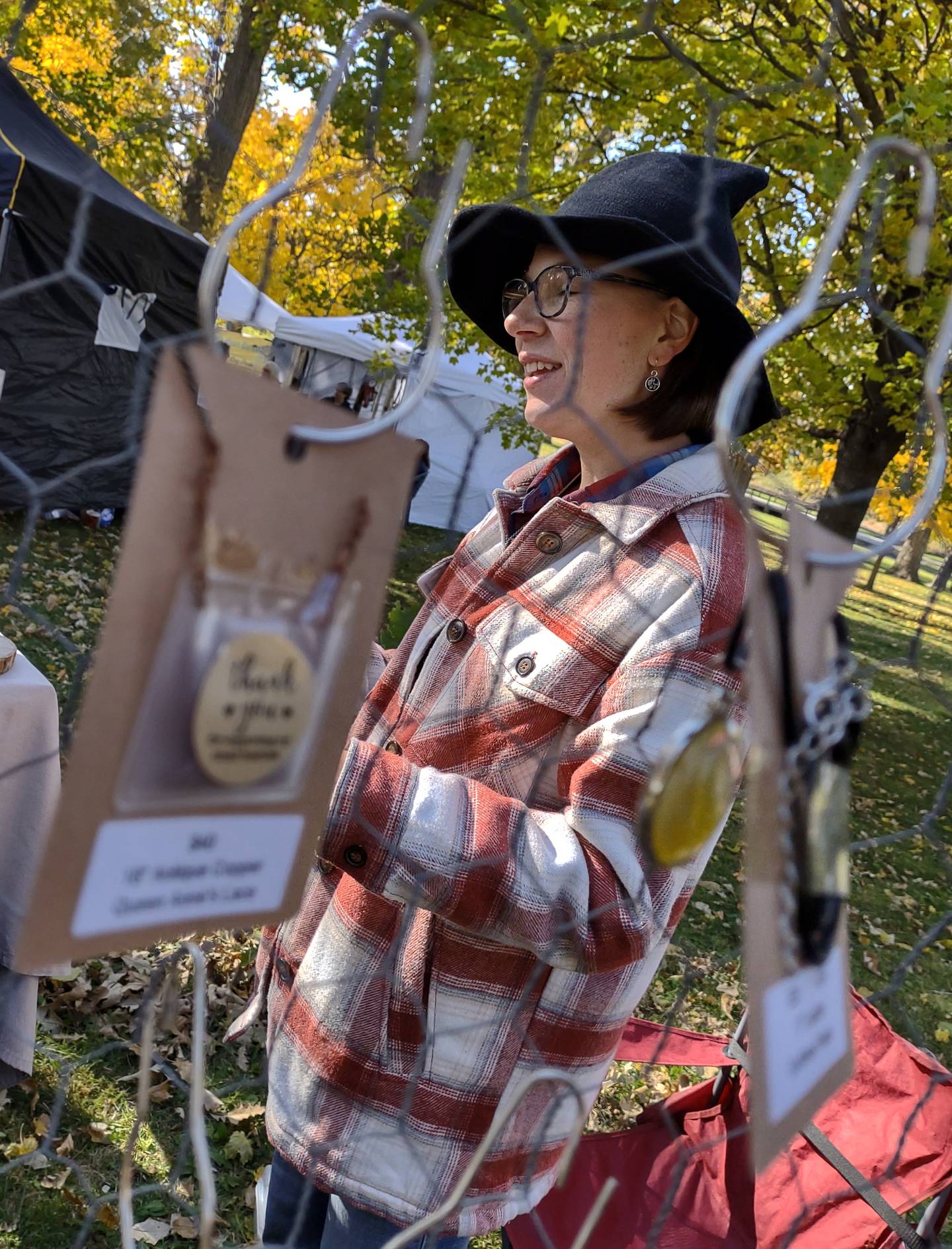 Tori Eisenberg of Sheridan tells customers about her handmade floral resin jewelry, which she sold Saturday, Oct. 22, 2022, at the Witches Day Out market at Pitstick Pavilion in Ottawa.