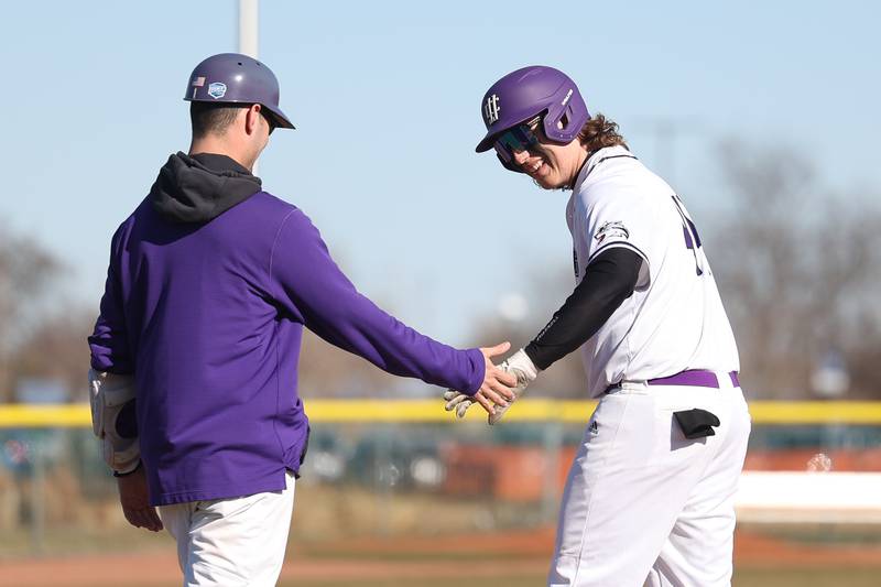 Joliet Junior College’s Preston Vowell is congratulated by the first base coach after his RBI single against Moraine Valley on Tuesday, March 7th, 2023.