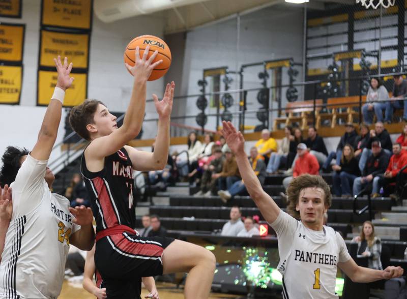 Henry-Senachwine's Landon Harbison scores on a layup over Putnam County's Alan Castro and Jacob Furar on Friday, Dec. 5, 2025 at Putnam County High School.