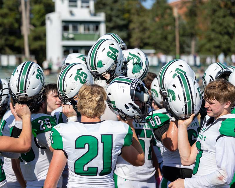 Dwight players raise helmets to break post-game huddle after big win against St. Bede on Saturday, Oct. 4, 2025 at Captain Thomas J. Heitmann field in Peru.