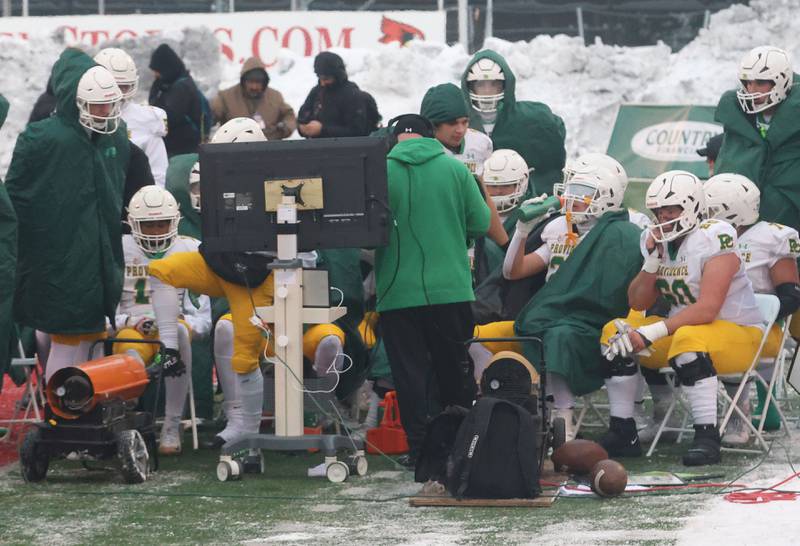 Members of the Providence Catholic football team watch film on the sidelines during the Class 5A State championship on Tuesday, Dec. 2, 2025 in Hancock Stadium at Illinois State University in Normal.