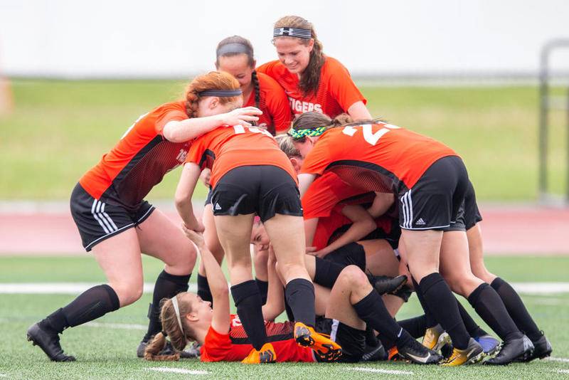 Teammates pile on Crystal Lake Central's Megan Wozniak after she scored the game-winning goal with 20 seconds remaining Saturday against Prairie Ridge at the Class 2A Hampshire Sectional championship in Huntley.