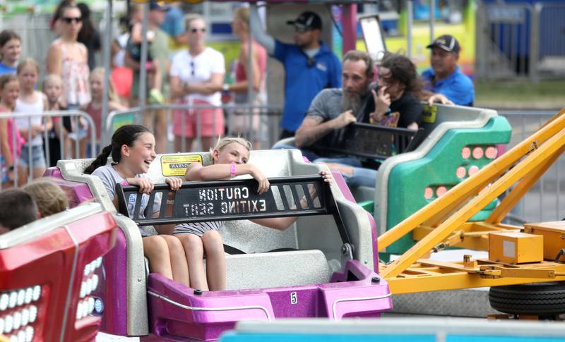 Sophie Ryan, 12, (left) and Ida Wendell, 12, ride one of carnival attractions on opening day of Swedish Days in Geneva on Wednesday, June 19, 2024.