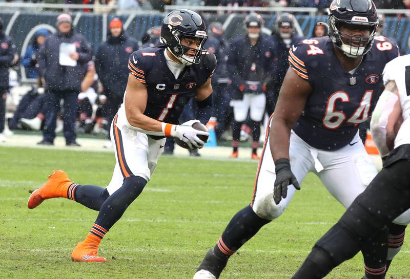 Chicago Bears quarterback Justin Fields scrambles away from the Atlanta Falcon pass rush for a touchdown during their game Sunday, Dec. 31, 2023, at Soldier Field in Chicago.