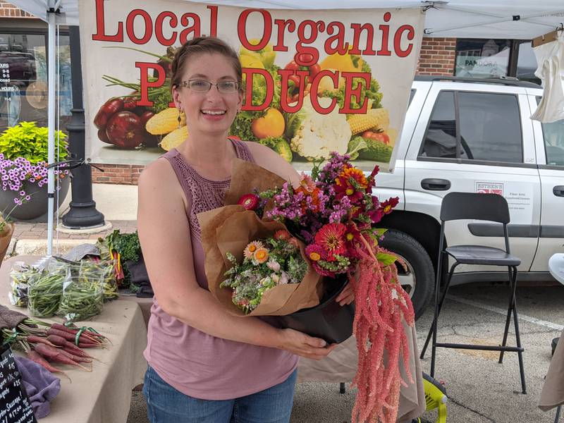 Natasha Lewis of Big Rock Organics shows some of the floral bouquets the business sells at the Oswego Country Market.