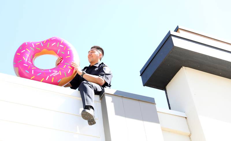 St. Charles Police Officer Chris Morales sits on top of the Dunkin’ Donuts on East Main Street in St. Charles on Friday, May 16. 2025 for the Cop on a Rooftop fundraiser for Special Olympics Illinois.