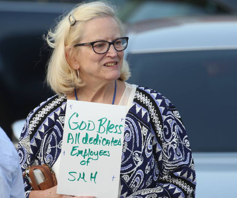 Evalyn Hassler holds a sign that reads "God bless all dedicated employees of SMH" during a gathering at St. Margaret's Hospital on Friday, June 16, 2023 in Spring Valley. Hassler worked at the hospital for 12 years and came back to show her support toward the employees.