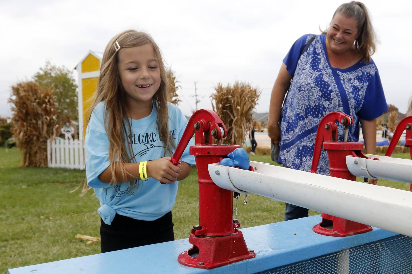 Kim Johnson, of Elgin, smiles as she watches daughter Francesca, 7, play in a duck race during the Fall on the Farm event at Tom's Market on Saturday, Oct. 2, 2021 in Huntley.  The month-long event began on Friday and will conclude Oct. 31.