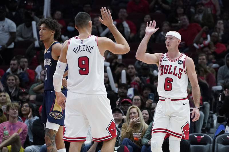 Chicago Bulls guard Alex Caruso, right, celebrates with center Nikola Vucevic after scoring a basket, as New Orleans Pelicans center Jaxson Hayes, left, looks to the bench during the second half of an NBA preseason basketball game in Chicago (AP Photo/Nam Y. Huh)