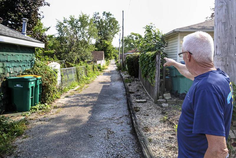 John Sheridan can be seen pointing down the alley behind his home Thursday, Sep. 17, 2020, in Joliet, Ill.
