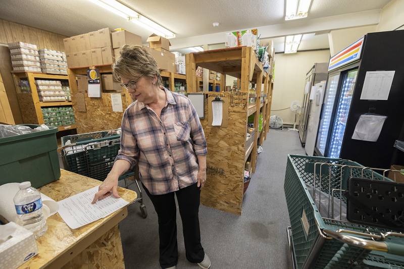 Dana Grace checks a list as she shops for a family Monday, Jan. 29, 2024 at the Dixon Food Pantry. The pantry is located at 2001 West 4th Street.