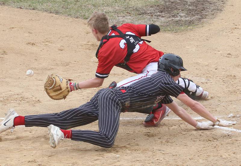 Hall's Hunter Edgecomb dives across home plate as the throw comes in late to Streator catcher Joe Hoekstra on Tuesday, March 18, 2025 in Foley Field at Kirby Park in Spring Valley.