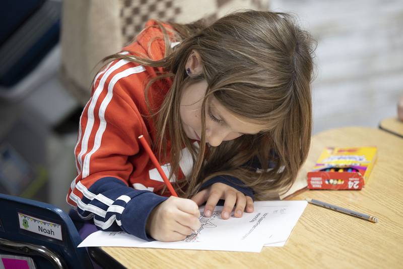 A third grader at Merrill School colors in a picture Monday, Nov. 10, 2025, in recognition of Veterans Day. All pictures colored in by the students will be sent to serving veterans. The school celebrated the holiday with speakers and projects throughout the school day.