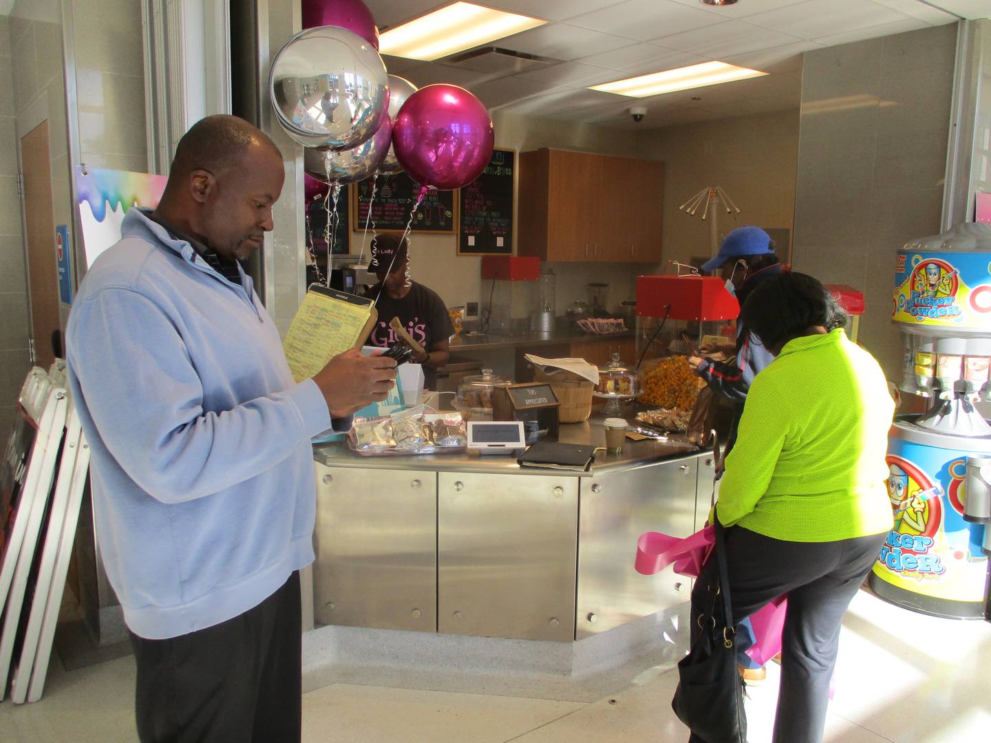 Doyle Landry of Chicago (left) was among customers stopping at Gigi's Sweets on the Go in the Gateway Center train station in Joliet on its first day of business Thursday,  Aug. 31, 2023.