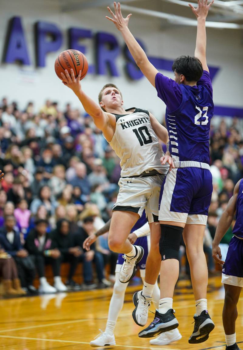 Kaneland’s Troyer Carlson (10) drives to the basket against Plano's Isaiah Martinez (23) during a championship game of the 60th annual Plano Christmas Classic Basketball Tournament at Plano High School on Saturday, Dec 30, 2023.