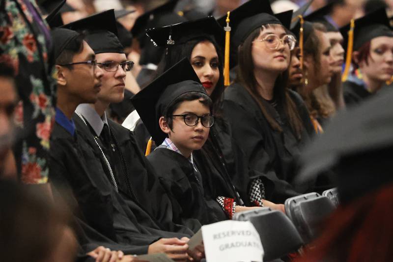 Benyamin Bamburc sits with other graduates at the Joliet Junior College Commencement Ceremony on Friday, May 19, 2023, in Joliet.