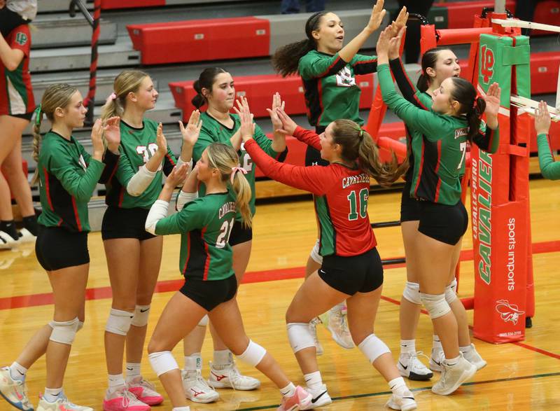 Members of the L-P volleyball team hi-five each other after deteating Kaneland in two sets and win the Interstate Eight Conference in AJ Sellett Gymnasium on Thursday, Oct. 24, 2024 at L-P High School.