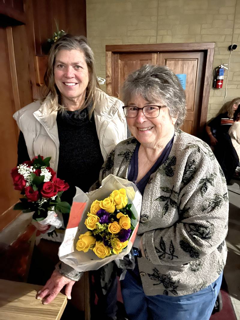 Robin Henry, left, and Sandy Harp won flowers in First Fridays’ monthly drawing. Randy Holland and Larry Wallace each won guitar accessories in the drawing for musicians.