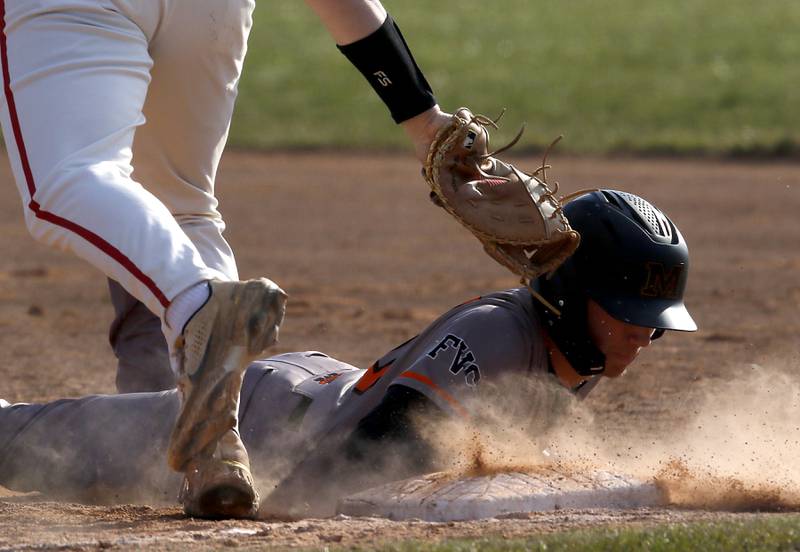 McHenry’s Nathan Neidhardt dives back to first base during a Fox Valley Conference baseball game against Huntley on Friday, April 11, 2025, at Huntley High School.