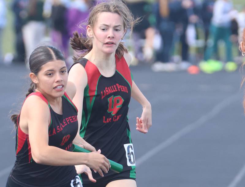 L-P's Gracie Politsch gets the baton from Bethany Kasperski in the 4x800 relay during the Class 2A Sectional track meet on Wednesday, May 13, 2026 in the Jeff Prusator Athletic Complex at Mendota High School.
