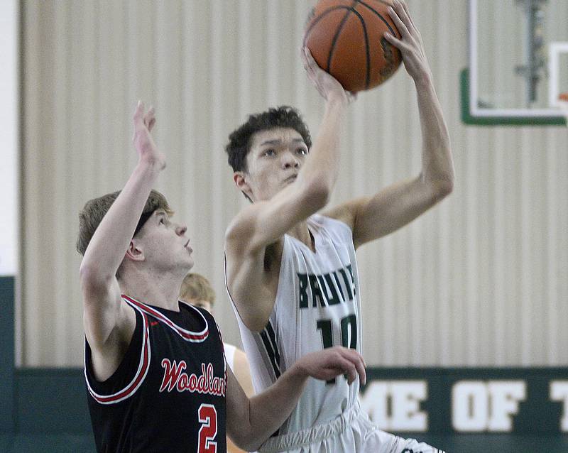 St Bede’s Isaiah Hart goes up and around Woodland’s Jon Moore for a layup during the 2nd period of the Class 1A Regional game on Saturday, Feb. 18, 2023 at St Bede.