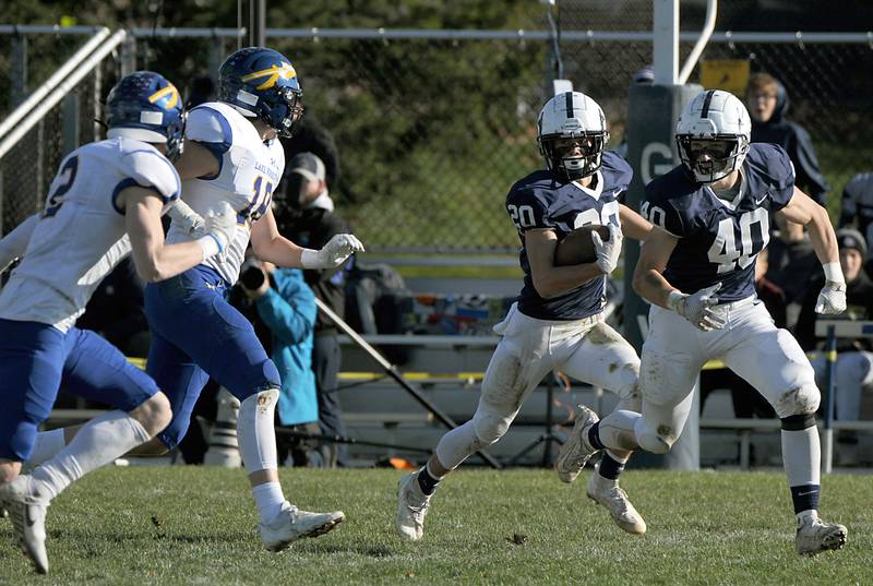 Cary-Grove's Drew Magel runs behind the block of his teammate, Wade Abrams, right, as he is chased by Lake Forest's Jake Milliman, left, and Brock Uihlein, second from left, during first quarter of the IHSA Class 6A semifinal football game between Lake Forest and Cary-Grove Saturday afternoon, Nov. 20, 2021, at Cary-Grove High School.