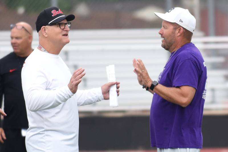 Bradley-Bourbonnais assistant football coach Dan Wetzel, left, and Wilmington head football coach Jeff Reents converse before the start of a joint summer workout at Bradley-Bourbonnais Wednesday, July 16, 2025.