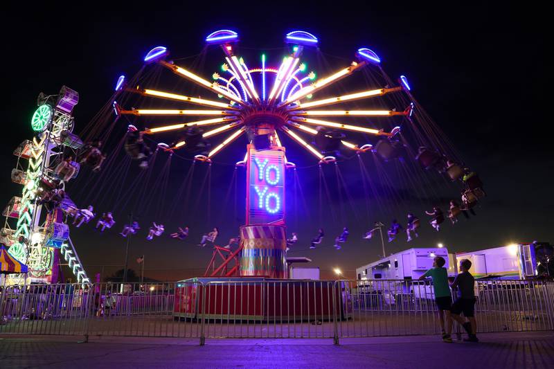 Fairgoers ride the swings at the carnival during the Will County Fair on Aug. 21, 2025.