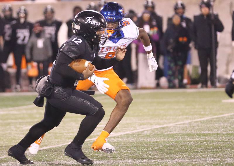 Fenwick quarterback Jamen Williams takes off on a run as East St. Louis's Jabarri Lofton defends during the Class 6A State championship game on Tuesday, Dec. 2, 2025 in Hancock Stadium at Illinois State University in Normal.