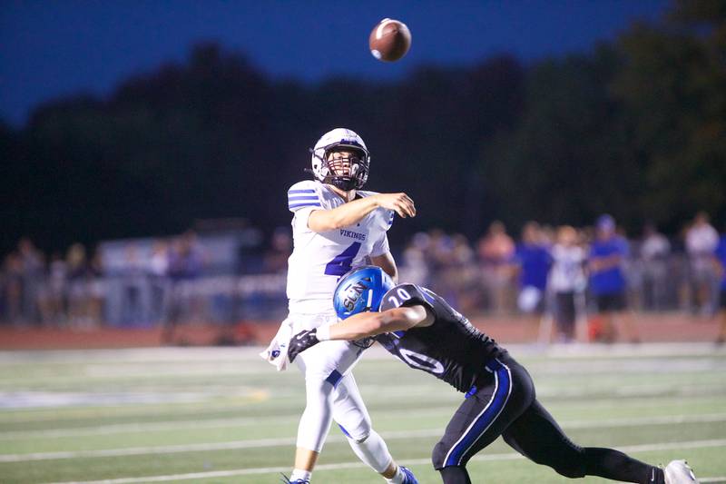Geneva's Benjamin Peterson throws the ball as he is tackled by St. Charles North's Brody Teafoe on Sept. 12, 2025 in St. Charles.