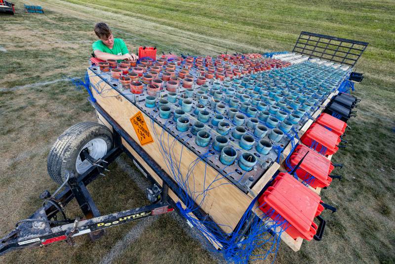 Jackson Hucheson of J&M Displays wires on of hundreds of firework shells prior to the start of the show at Bill Novak Field on July 4, 2025 at Ottawa High School.