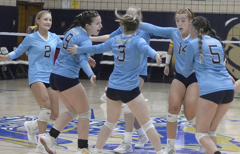 The Marquette Lady Crusaders celebrate a point late in the first match against Reed Custer Monday at Marquette.