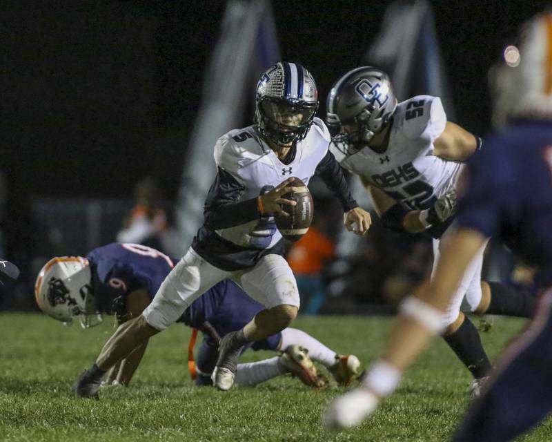 Oswego East's Nicko Villacci (5) scrambles away from the pass rush during football game between Oswego East at Oswego Friday, Oct 17, 2025 in Oswego.