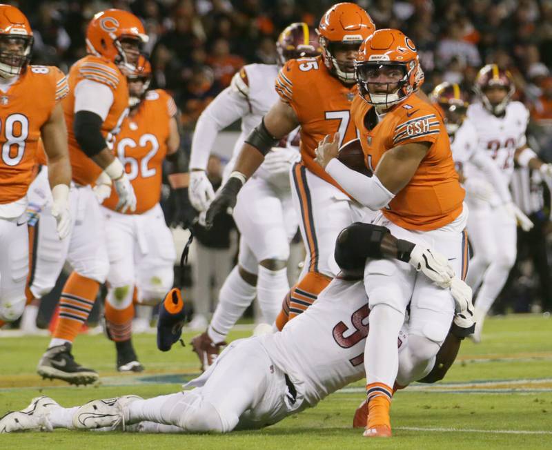 Chicago Bears quarterback Justin Fields avoids a sack from Washington Commanders Efe Obada (97) on Thursday, Oct. 13, 2022 at Soldier Field.