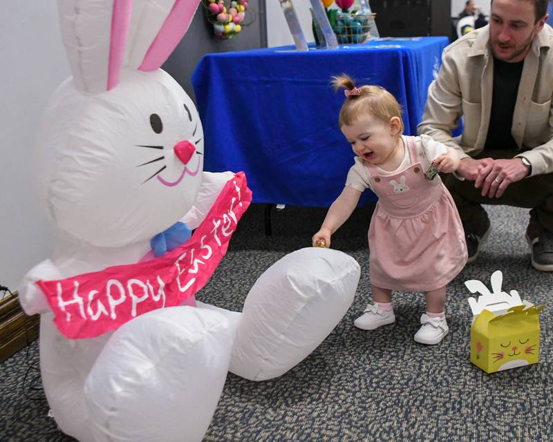 Emma Dawson, 16 months, is all smiles as she gets distracted from her goodie bag to check out a blowup bunny on Saturday March 29, 2025, during the breakfast with the bunny event held at the La Grange Park District Recreation Center.