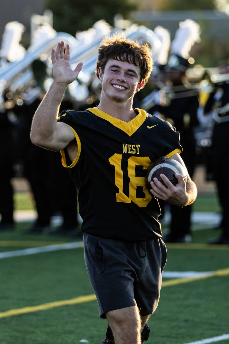 Joliet West's Aidan O'Malley waves to supporters while taking the field for a varsity football home game against Plainfield South on Sept. 12, 2025.