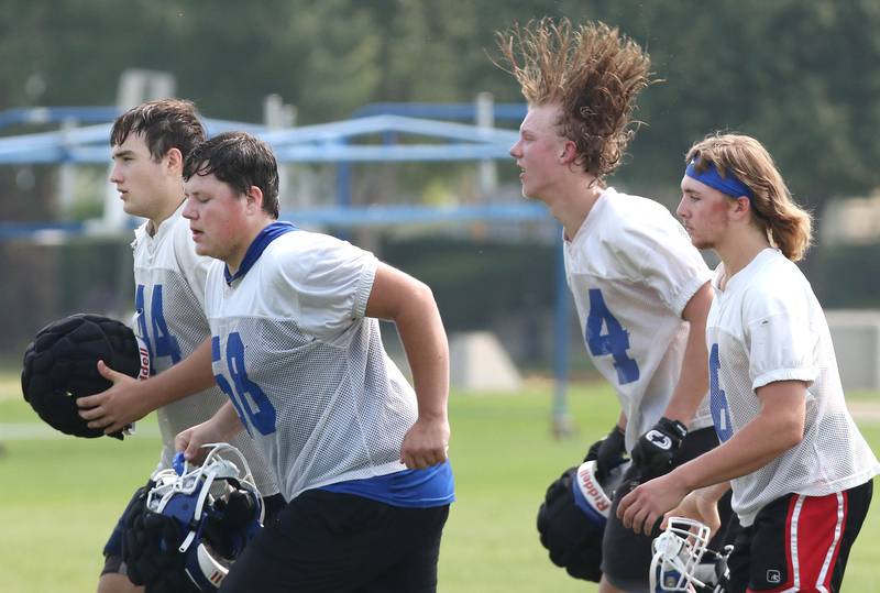 Genoa-Kingston players run off the field for a water break during practice Monday, July 24, 2023, at the school in Genoa.