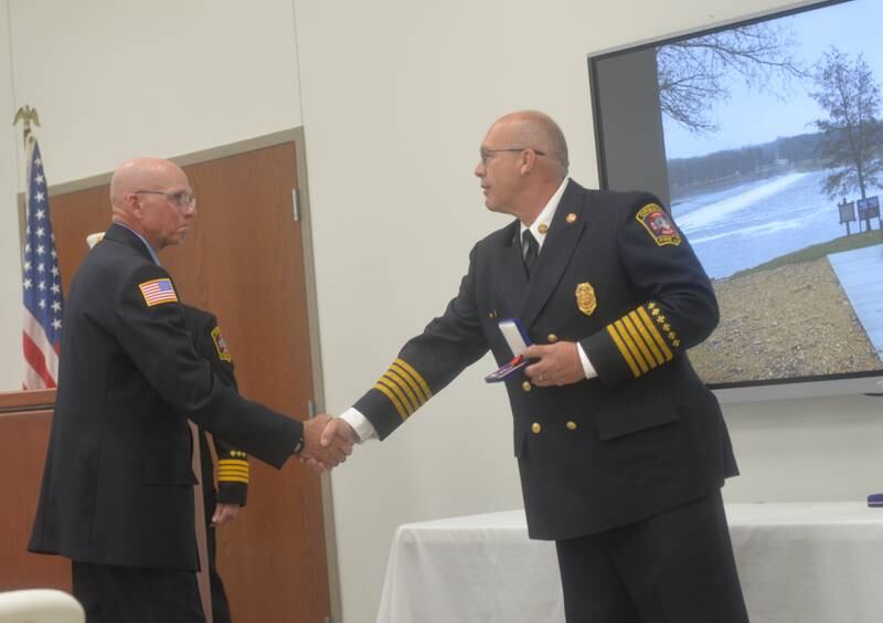 Oregon Fire Chief Mike Knoup presents Greg Hunter (left) with a Medal of Valor for his efforts in saving a woman from the Rock River in December 2022.