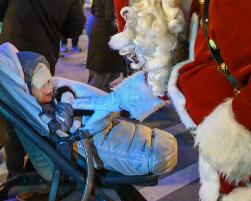 Santa Clause says hello to Emilia Nagel, 2, on Friday Nov. 29, 2024, after the Christmas tree lighting ceremony held in downtown Downers Grove.
