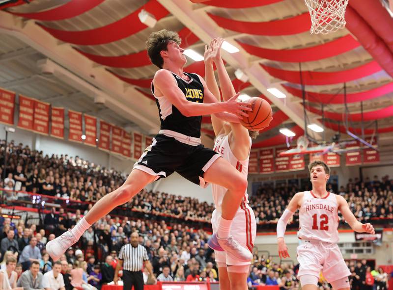 Lyons' Connor Carroll (14) takes to the air during the boys 4A varsity sectional semi-final game between Hinsdale Central and Lyons Township high schools in Hinsdale on Wednesday, March 1, 2023.