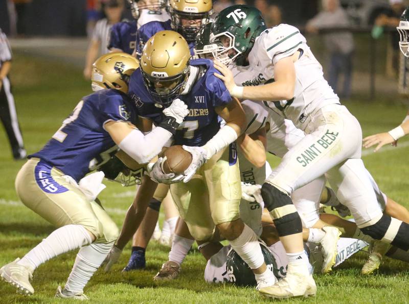 Marquette's Blayden Cassel runs with the ball as St. Bede's Kahne Gentert (no.26) defends on Friday, Sept. 26, 2025 at Gould Stadium in Ottawa.